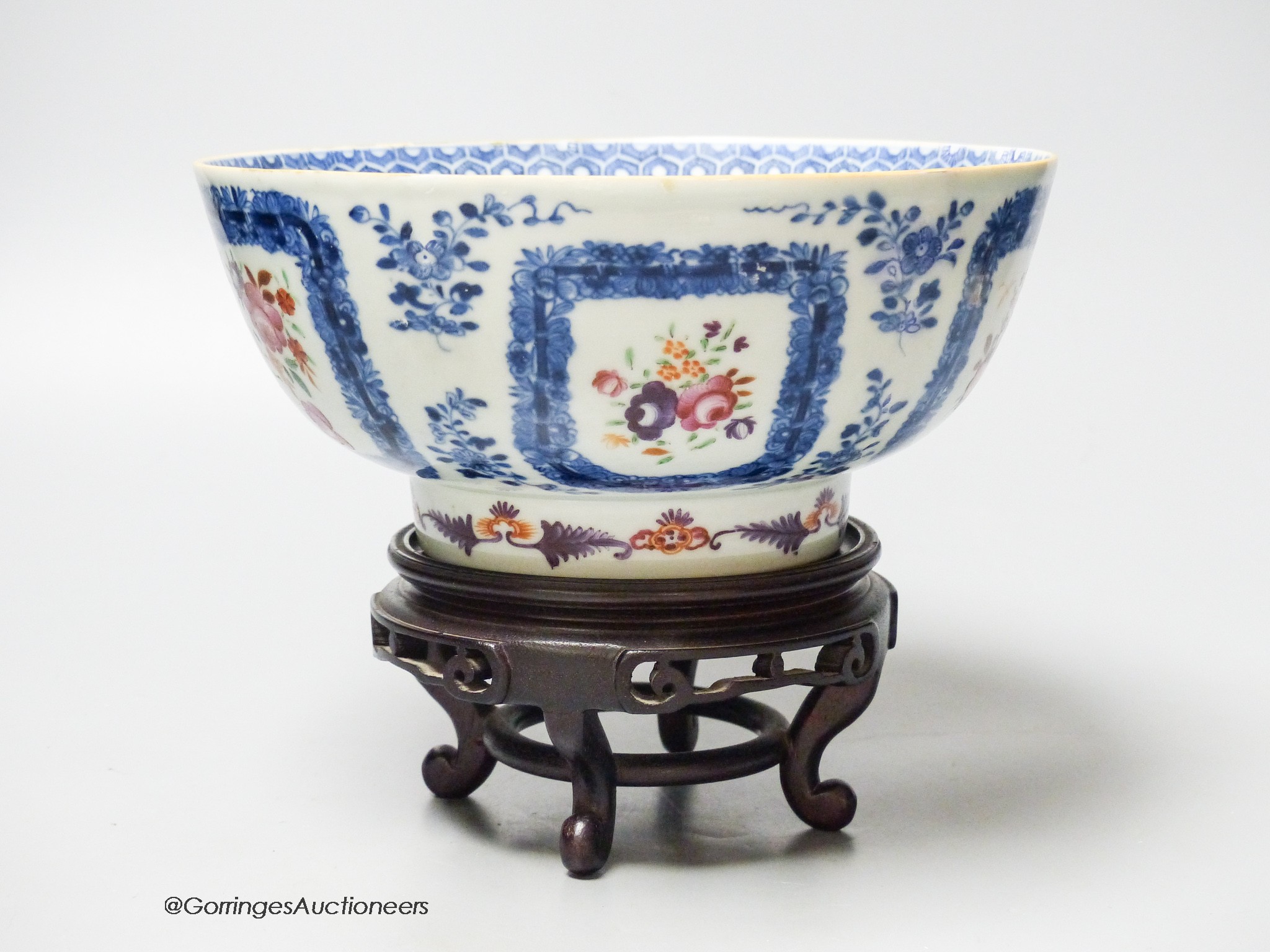 A 18th century Chinese export porcelain footed punch bowl on hardwood stand, diameter 20cm, restored